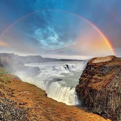 rainbow over a cliff waterfall in iceland